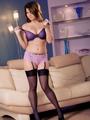 Busty brunette poses in kinky lingerie and sheer stockings.